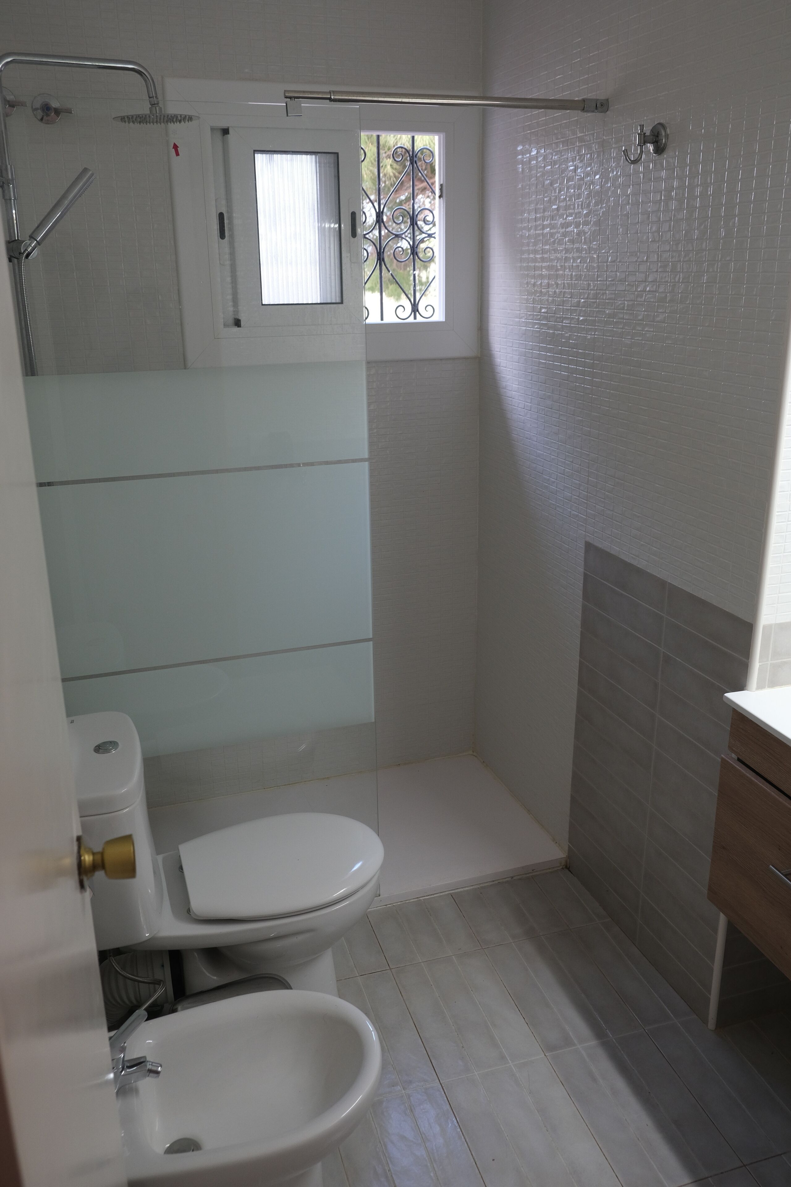 Un baño con inodoro, bidé y ducha.