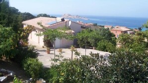 Ein Küstenwohngebiet mit Reihenhäusern, freiem Blick auf das Meer und üppigem Grün.