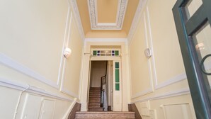 A staircase leading to a door with a decorative ceiling and a stained glass window. - Portuguese Soul Bica | Iconic Tram View & Patio | Sleeps 4 (Lisboa)