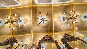 A luxurious room with ornate chandeliers, mirrored walls, and a golden ceiling. - Portuguese Soul Bica | Iconic Tram View & Patio | Sleeps 4 (Lisboa)