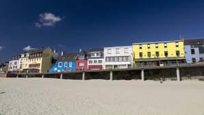 A row of colorful buildings along a beach, including a restaurant and a hotel. - MORGAT 70 meters Beach, 8 people with garden and parking (Crozon)