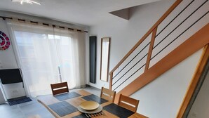 A dining area with a wooden table and chairs, a bench, a ceiling fan, and a staircase. - House on the seafront, beach 150 m away  (Île-Tudy)