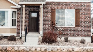 A two-story house with a brick facade and a grey roof. - Charming Home North Logan 3BD/2.5BA Sleeps 6 (North Logan)
