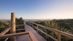 A wooden boardwalk leading to a beach with a metal structure on the left. - Edisto 2BR W/Resort Amenities and beach access (Edisto Island)