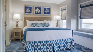 A neatly arranged bedroom with a large bed, two bedside tables with lamps, and a window with blinds. - Edisto 2BR W/Resort Amenities and beach access (Edisto Island)