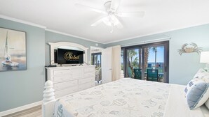 A bedroom with a bed, a TV, a dresser, and a view of the outdoors. - Ground-Floor | Huge Patio | Steps to Pool and Beach | FLPCB9 (Panama City Beach)