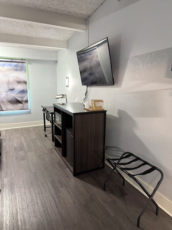 A modern office space with a desk, chair, and a mounted TV.