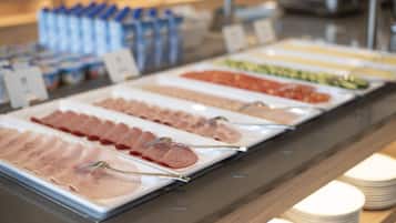 Un bufé con diferentes alimentos dispuestos en bandejas.