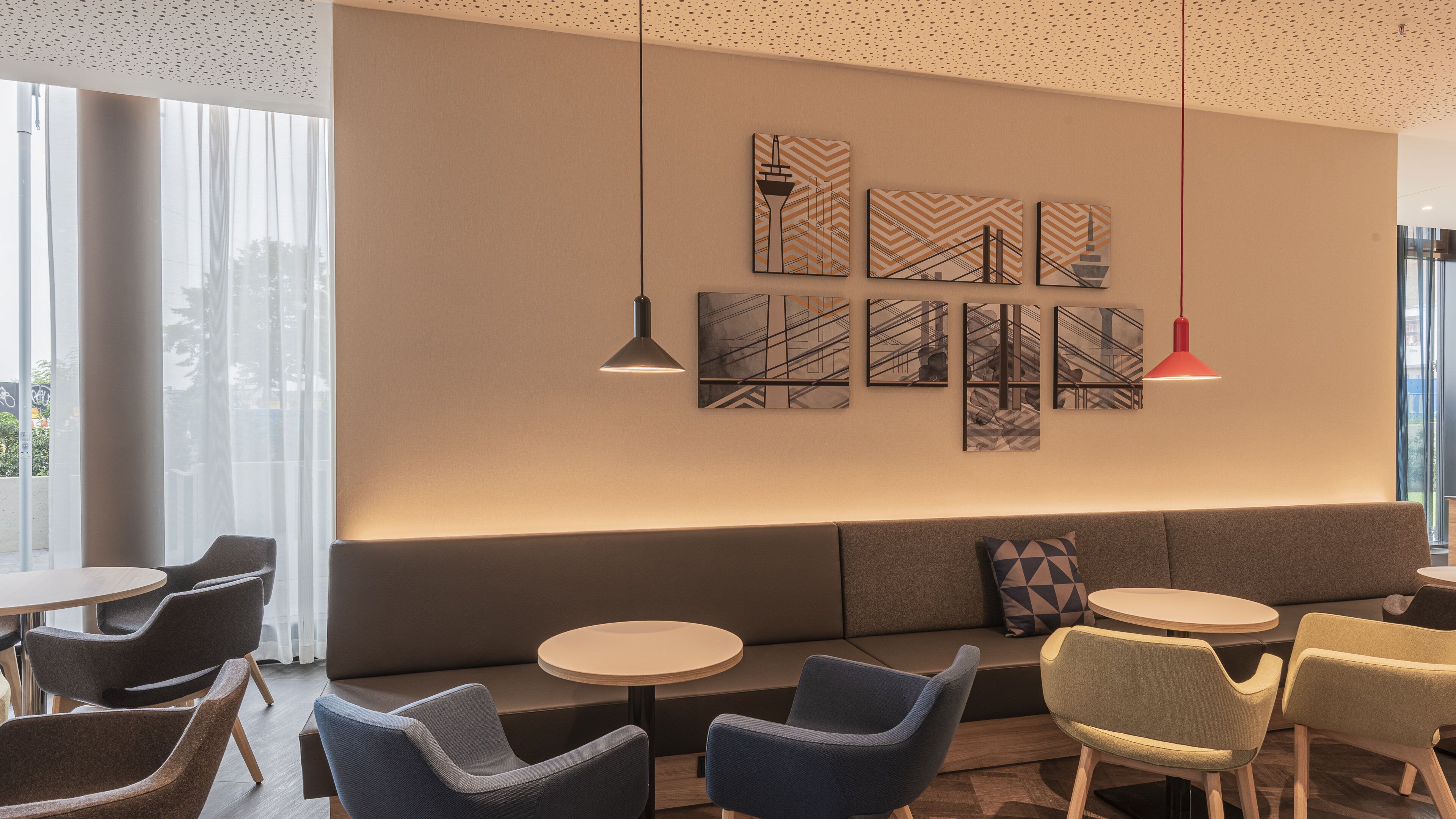 Un espace de détente moderne avec un canapé, des tables rondes et des chaises.