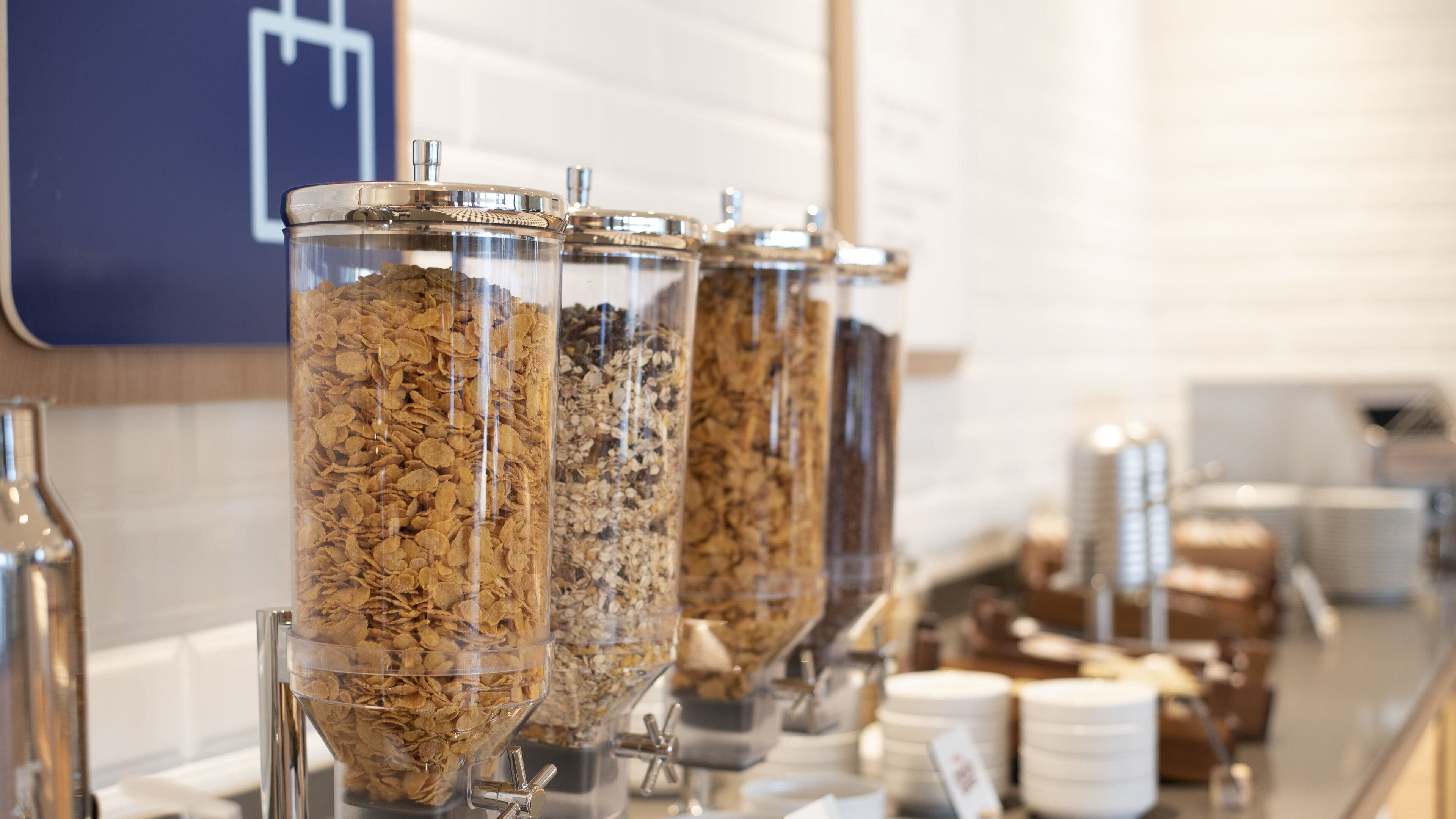 Una barra de desayuno con varios recipientes de cereales.