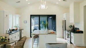 A modern kitchen with white cabinetry, a central island, and a chandelier. - Luxury in DT Tempe -2 en-suites - ASU, Spring Training, Golf & More (Tempe)