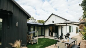 A modern house with a patio area featuring a dining table, chairs, and a swing chair. - Luxury in DT Tempe -2 en-suites - ASU, Spring Training, Golf & More (Tempe)
