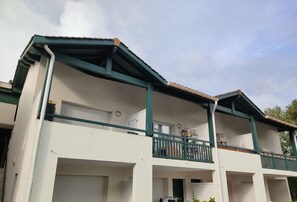 Un edificio de dos plantas con un balcón en el piso superior.