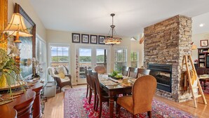A dining area with a stone fireplace, a large rug, and a view of the outdoors. - Blue Door - Entertainment area downstairs with a pool table (Arley)