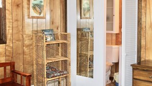 A rustic bathroom with wooden walls, a white door, and a wicker shelf with towels. - Book your SUMMER FUN now - lakes, waterfalls, ATV/UTV trails! Your fun awaits! (Crivitz)