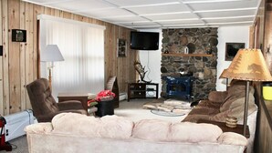 A cozy living room with a stone fireplace, comfortable seating, and a television. - Book your SUMMER FUN now - lakes, waterfalls, ATV/UTV trails! Your fun awaits! (Crivitz)