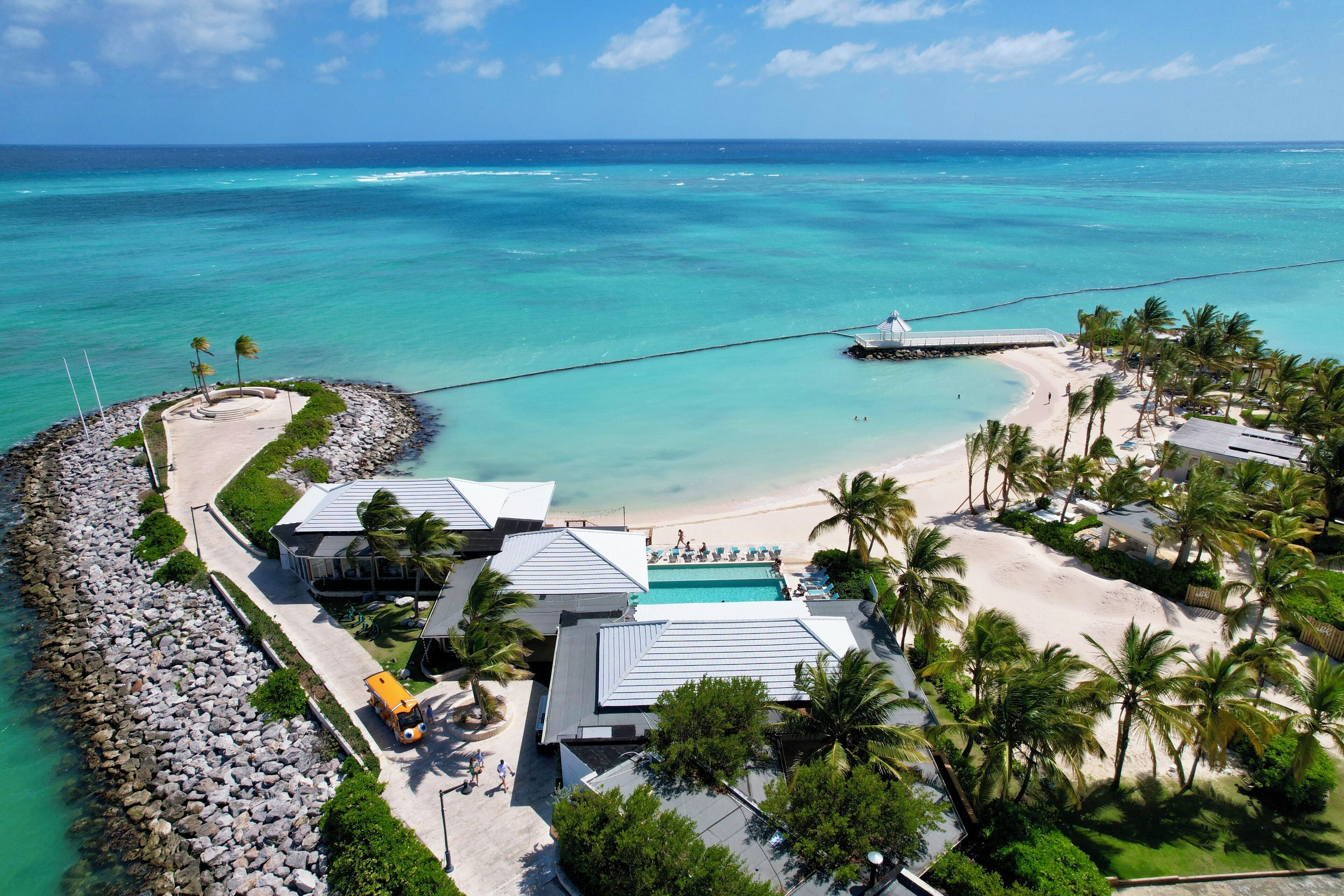 Un complexe hôtelier doté d’une piscine, d’une plage et offrant une vue sur l’océan.