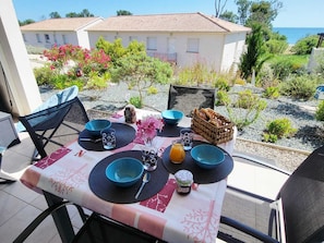 A table set outdoors with a view of a building and the sea. - T3 sea view - beach & pool with all comforts (Linguizzetta)