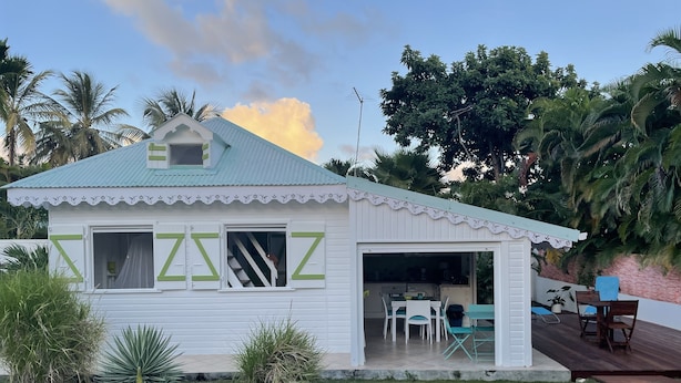 A small, white building with a green roof and a covered patio area. - Bungalow with private Jacuzzi (Saint-François)