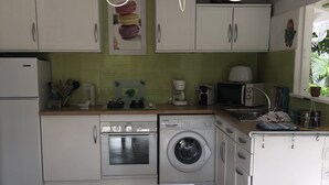 A modern kitchen with white cabinets, a microwave, a coffee maker, and a washing machine. - Bungalow with private Jacuzzi (Saint-François)
