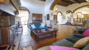 A spacious living area with a fireplace, sofas, and a coffee table. - Villa Radda by MMega (Gaiole In Chianti)