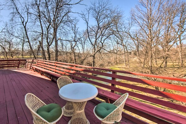 A wooden deck with wicker chairs and a table, overlooking a natural landscape with trees and a fence. - Creek Access & Deck: ‘Runningwater’ Lancaster Gem (Lancaster)