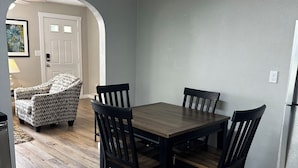 A dining area with a wooden table and chairs, a sofa, and a door. - Hidden Gem-10 minutes to DT Chatt! Perfect for teleworkers, small families, etc. (Rossville)