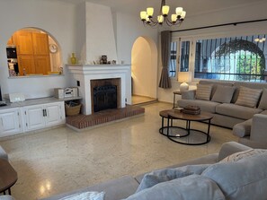 Smart TV, lareira, livros, aparelho de som