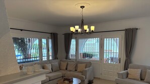 A living room with a sofa, a coffee table, and a chandelier. - Villa with private pool, pool table & Sea Views – Short Walk to Beach & Town (Mijas)