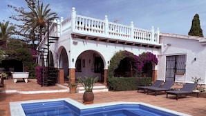 A pool with a white balustrade, a covered patio area, and a building with arches and a balcony. - Villa with private pool, pool table & Sea Views – Short Walk to Beach & Town (Mijas)