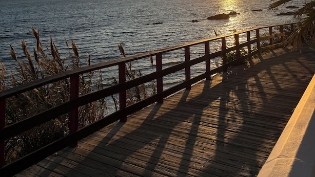 A wooden deck with a railing overlooking a body of water during sunset. - Villa with private pool, pool table & Sea Views – Short Walk to Beach & Town (Mijas)