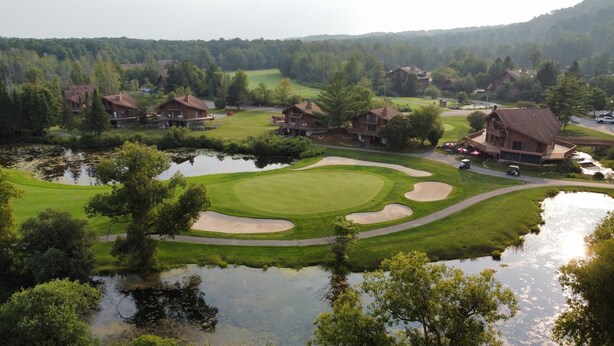 A golf course with bunkers, water hazards, and a clubhouse. - Newly decorated 2 BR 2 bath Sleeps 6 outdoor pool, close to Torch Lake, wifi (Mancelona)