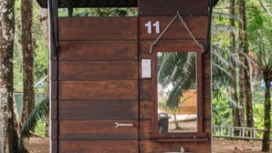 A small wooden structure with a number 11 on it, a sink, and a mirror. - Roxy Telok Serabang (Lundu)