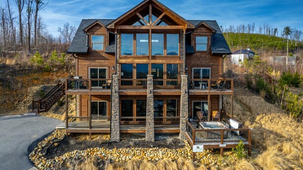 Ein großes, mehrstöckiges Holzhaus mit Balkon und Whirlpool.