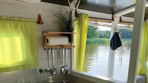 Een kleine keukenhoek met een spoelbak, fornuis en kastjes.