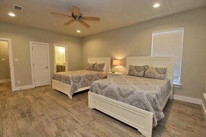 A bedroom with two beds, a ceiling fan, and a window with blinds. - Hammock Dunes J (Orange Beach)