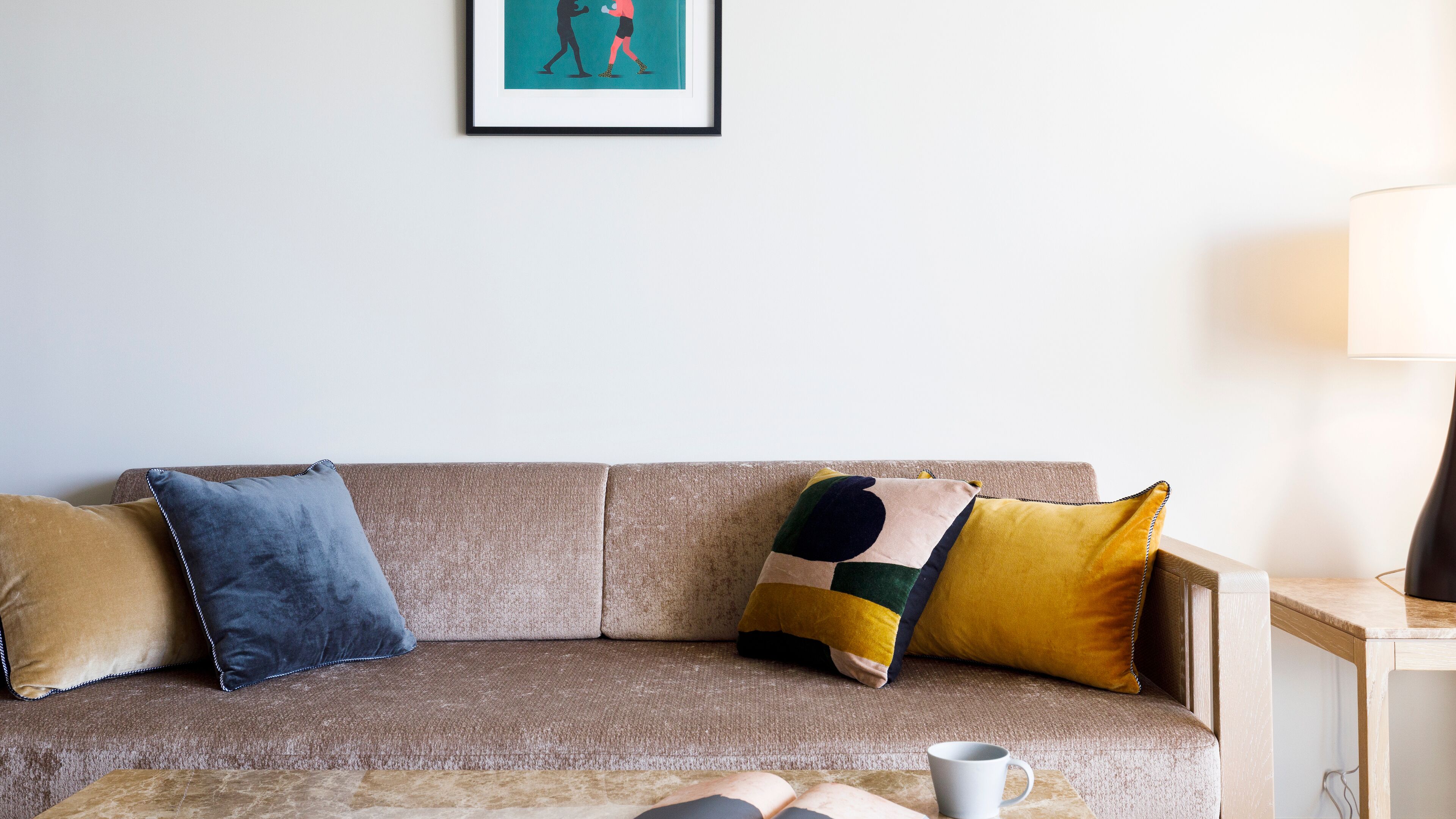 A living room with a sofa, a coffee table, and a lamp.