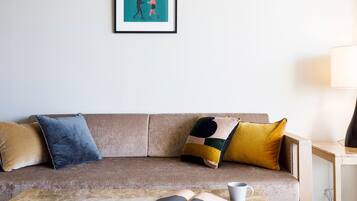 A living room with a sofa, a coffee table, and a lamp.