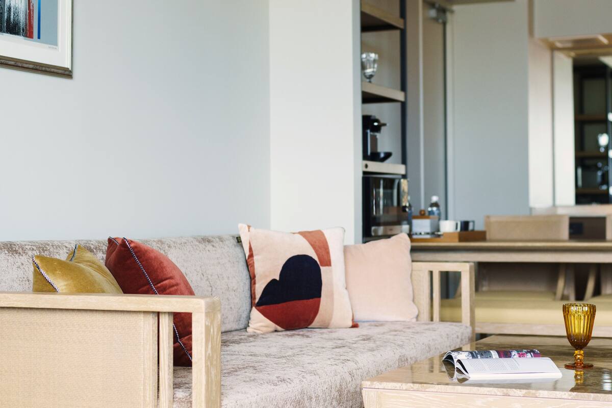 Uma sala de estar moderna com sofá, mesa de centro e um copo de vinho.