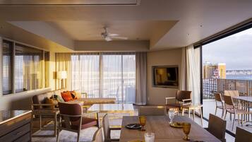 A modern hotel room with a balcony, a dining area, and a large window offering a city view.