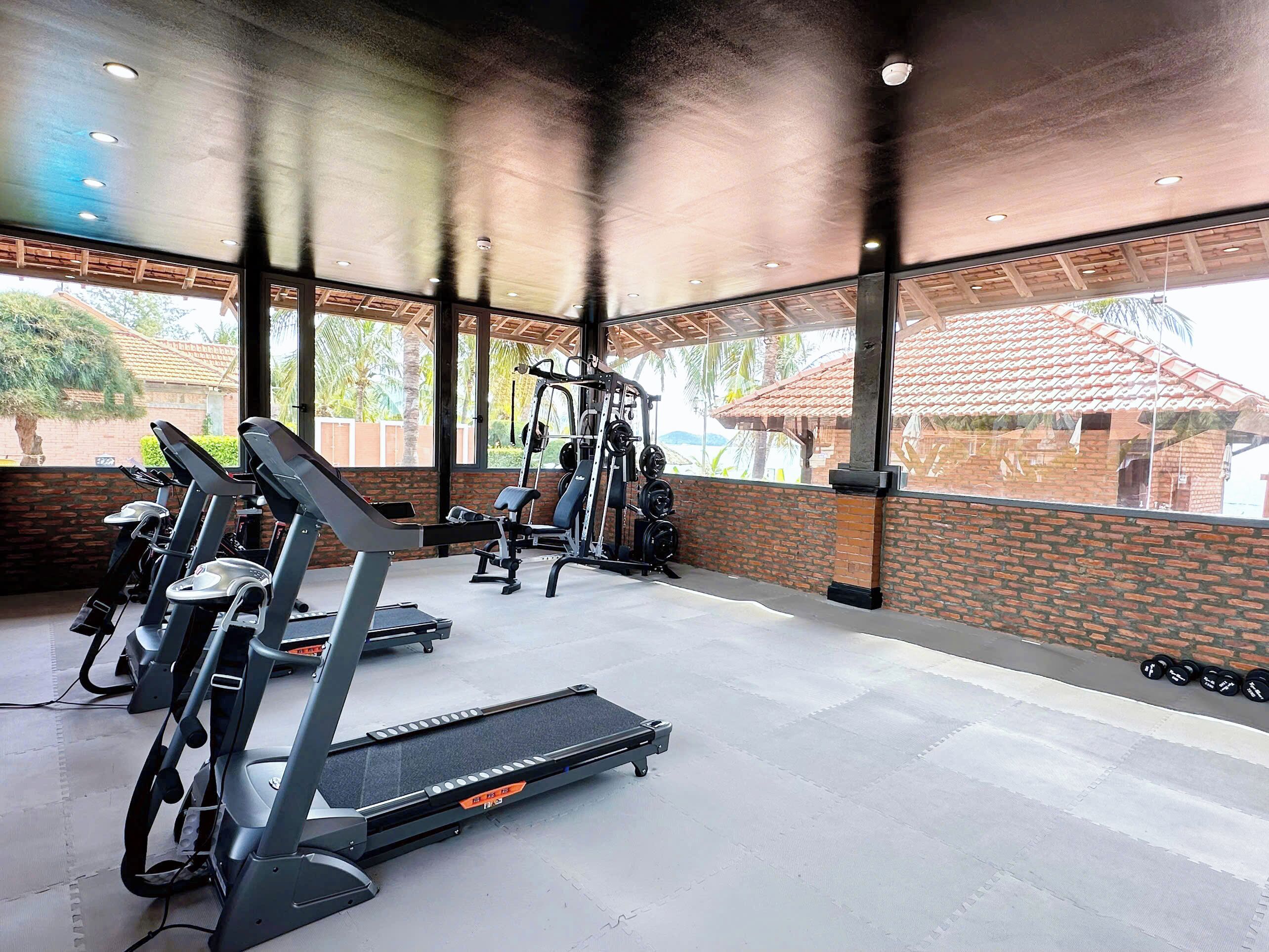 A gym with treadmills, weight machines, and a bench.