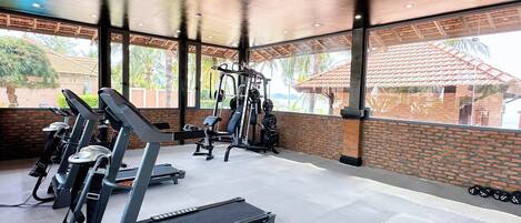 A gym with treadmills, weight machines, and a bench.