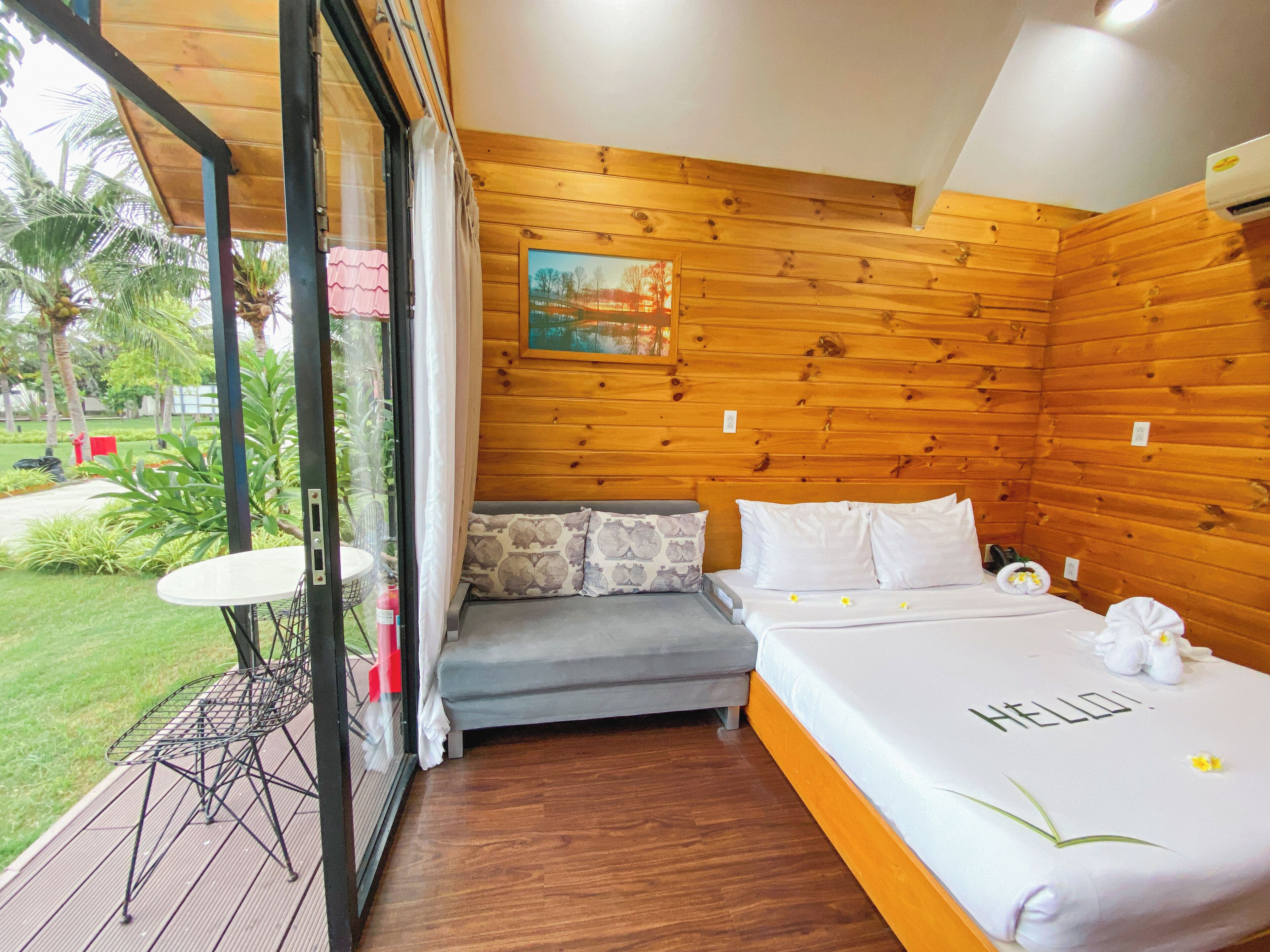 Une chambre avec un mur en bois, un lit avec une literie blanche et une petite table avec une chaise.