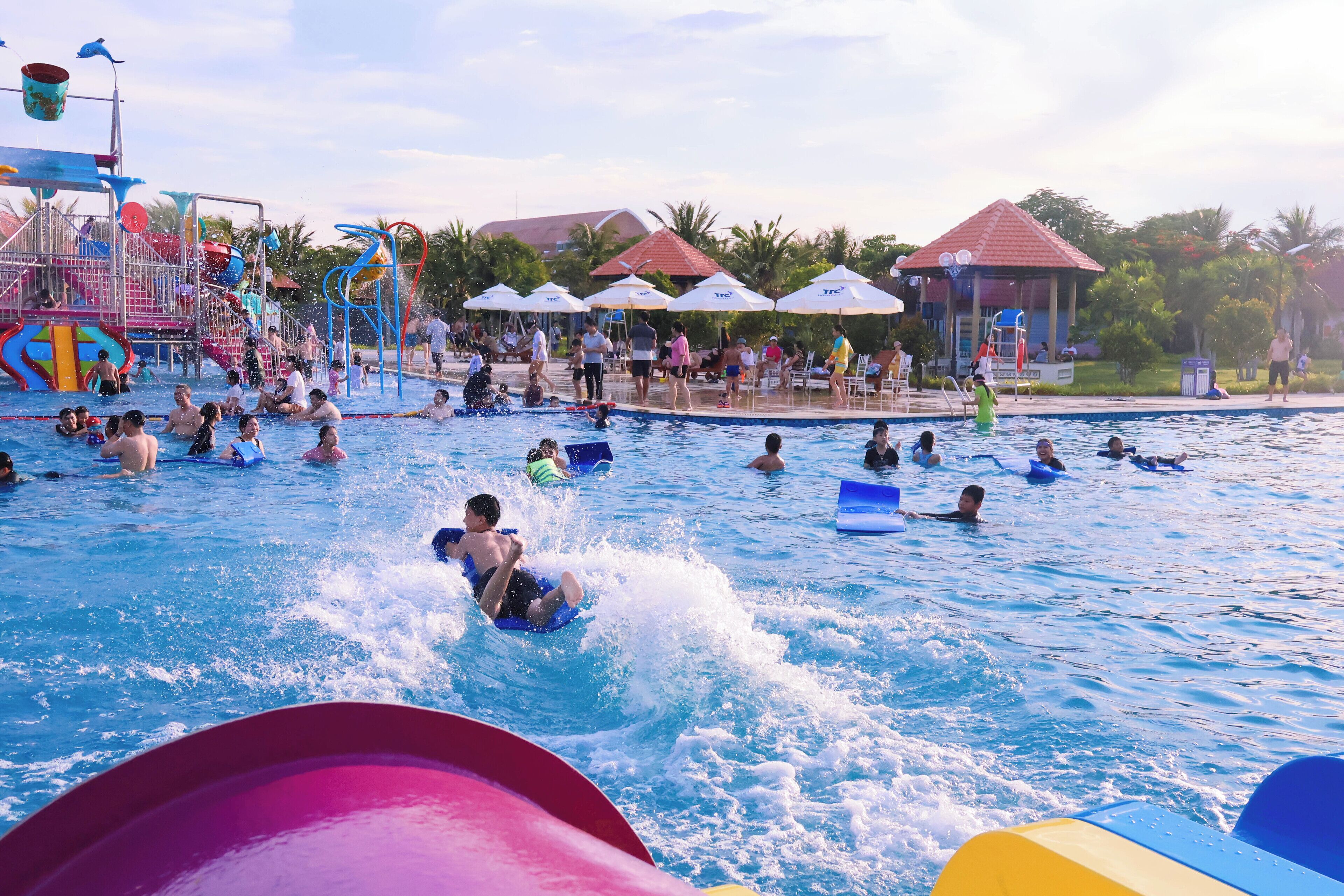 A swimming pool area with multiple water slides and a water park structure.