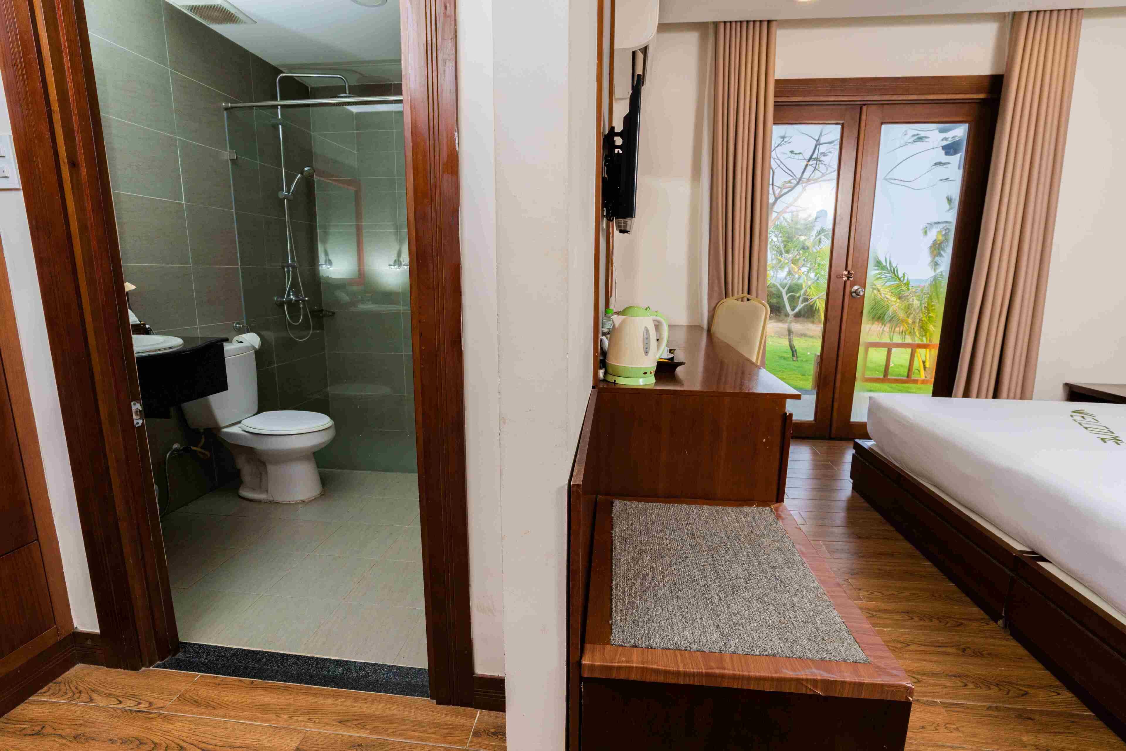 Une chambre d’hôtel avec un bureau en bois, un lit, une douche et une vue sur l’extérieur.