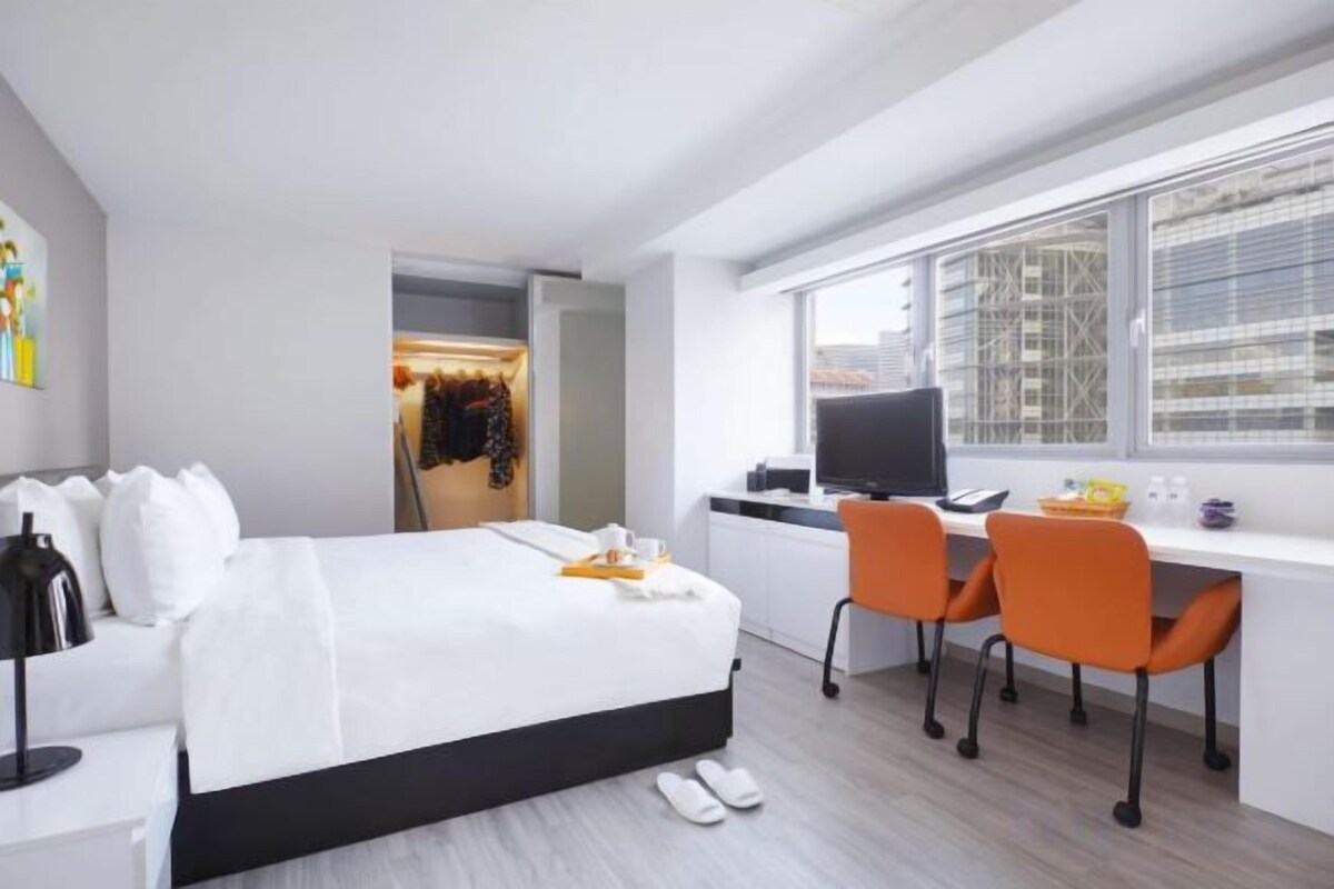 Una habitación de hotel moderna con cama, escritorio y sillas.