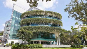 A modern building with a curved facade, a green rooftop garden, and a sign reading "Singapore Management University". - Wilby Central Serviced Apartments (Singapore)