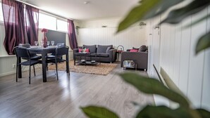 A modern living room with a dining table, two sofas, and a coffee table.