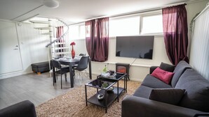 A living room with a sofa, coffee table, and a spiral staircase.