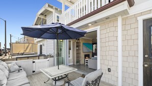 A patio with a table, chairs, and an umbrella.